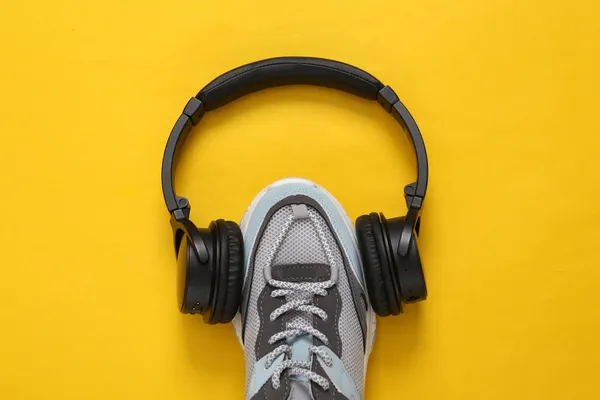stock image Sports shoe with headphones on yellow background. Fitness concept. Top view. Minimalism