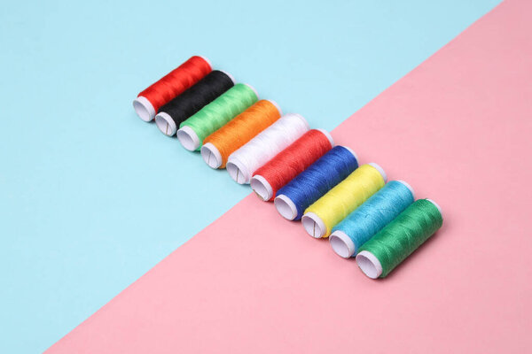 Skeins of colored thread on a blue-pink pastel background