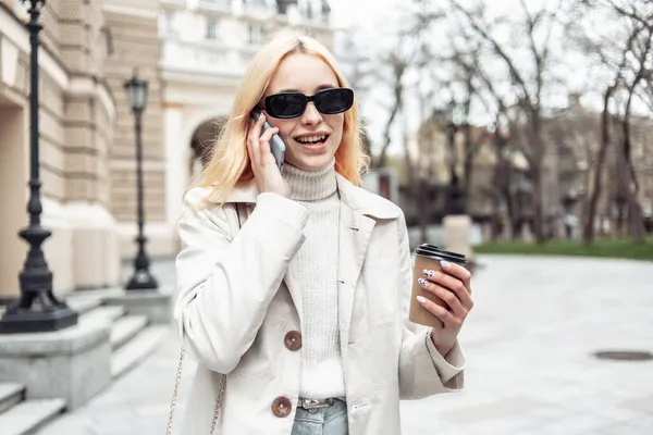 Mladé Blondýny Žena Slunečních Brýlích Mluví Telefonu Drží Šálek Kávy — Stock fotografie