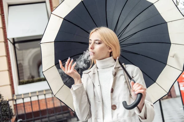 Junge Blonde Frau Raucht Elektronische Zigarette Unter Regenschirm Der Stadt — Stockfoto
