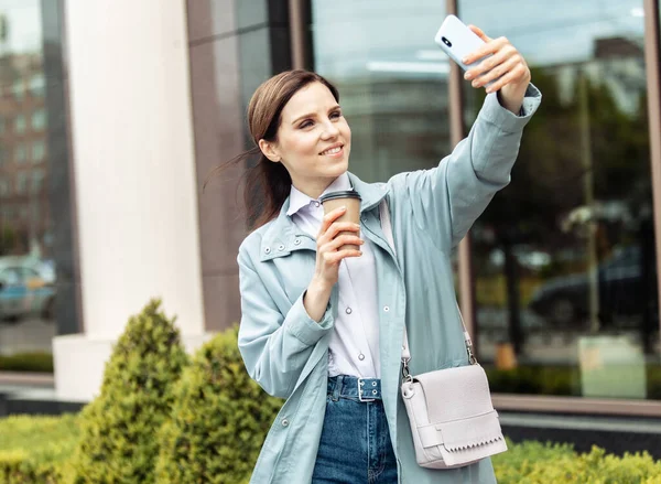Biznesmenka Płaszczu Robi Selfie Przez Telefon Pije Kawę Podróży Mieście — Zdjęcie stockowe