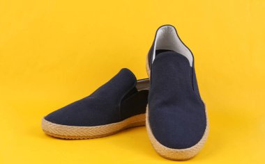 Sarı arka planda erkek espadrilles. Erkek yaz ayakkabıları.