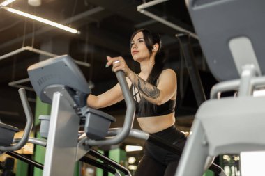 Genç fitness kadını spor salonunda egzersiz makinesinde vücut çalışıyor. Sağlıklı yaşam tarzı, spor anlayışı