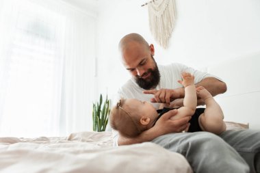 Önemseyen baba, küçük kızıyla yatak odasında oynuyor. Sevgi ve ilgi, mutlu aile, birlikte zaman geçirme konsepti.