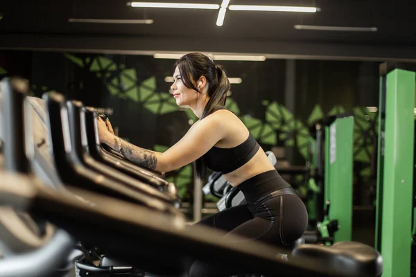 Ελκυστική Γυναίκα Γυμναστικής Κάνει Καρδιο Προπόνηση Ποδήλατο Μηχανή Άσκησης Στο — Φωτογραφία Αρχείου