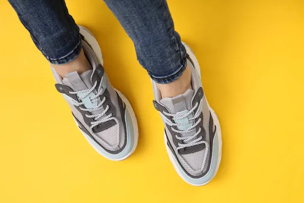 Kvinnliga Ben Fashionabla Jeans Och Sneakers Gul Bakgrund — Stockfoto