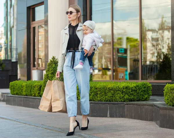 Moderna Mãe Elegante Com Sua Filha Seus Braços Sacos Compras — Fotografia de Stock
