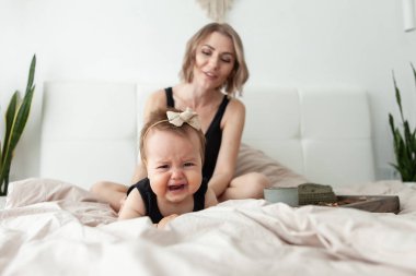 Annesiyle yatak odasında ağlayan küçük bir kız.