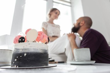 Yıldönümü kutlaması. Romantik, aşk konsepti. Üzerinde 5 yaşında bir yazı olan bir pastanın yakın çekimi ve arka planda sevgi dolu genç bir çift..