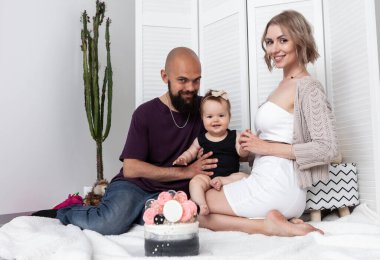 Mutlu aile kavramı. Anne ve küçük kızını önemseyen baba doğum günlerini pastayla kutluyorlar. Sevgi ve ilgi. Çocukluk. Tatil