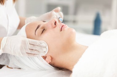 Kozmetik uzmanı, güzel bir kadının dudak büyütme ve kırışıklık önleyici iğneleri yapar. Güzellik salonunda kadın kozmetolojisi.