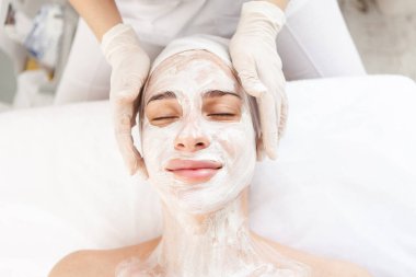 Cilt bakımı. Gençleştirici maskeli güzel bir kadın. Güzellik salonunda gözleri kapalı.