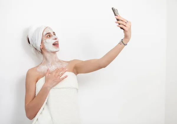 Mooie Vrouw Met Gezichtsmasker Maakt Selfie Smartphone Witte Achtergrond Huidverzorgingsconcept — Stockfoto