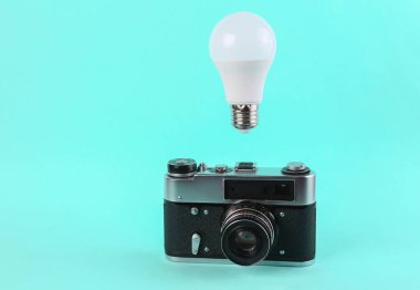 Mavi arka planda ampullü kamera. Asgari ilham kavramı