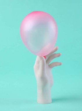 Parlak mavi arka planda el ele tutuşan pembe balon. Asgari yaratıcı düzen. Sanat kavramı