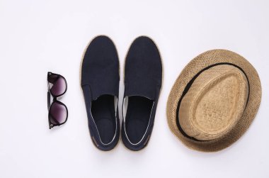 Erkekler hasır şapka, güneş gözlüğü ve beyaz arka planda ayakkabılar. Üst Manzara. Düz yatıyordu