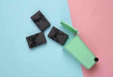 Mavi pastel arka planda hediye kutuları olan çöp kutusu.