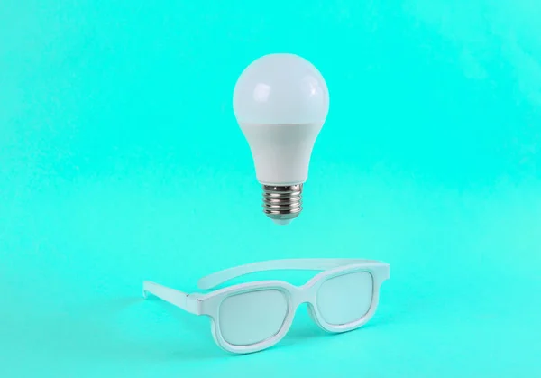 Weiße Gläser Und Schwebende Glühbirne Auf Hellblauem Hintergrund Inspiration Idee — Stockfoto