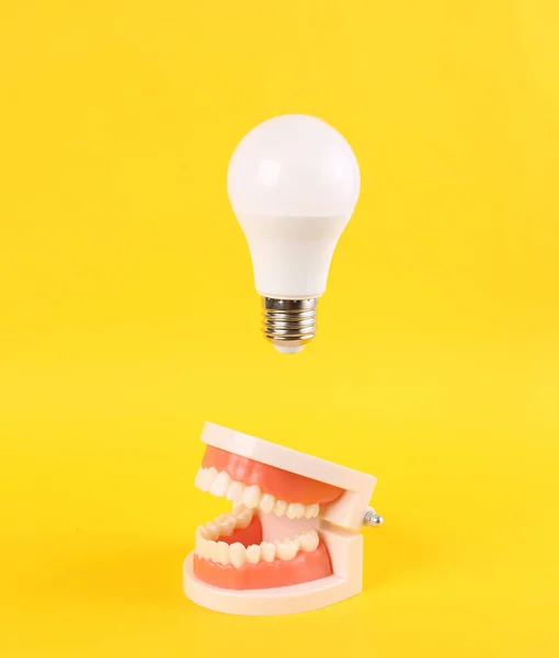 Artificial Jaw Floating Light Bulb Yellow Background Minimal Idea Inspiration — Stock Photo, Image