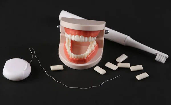Zahnpflegekonzept Kiefermodell Mit Weißen Zähnen Zahnbürste Zahnseide Und Kaugummi Auf — Stockfoto
