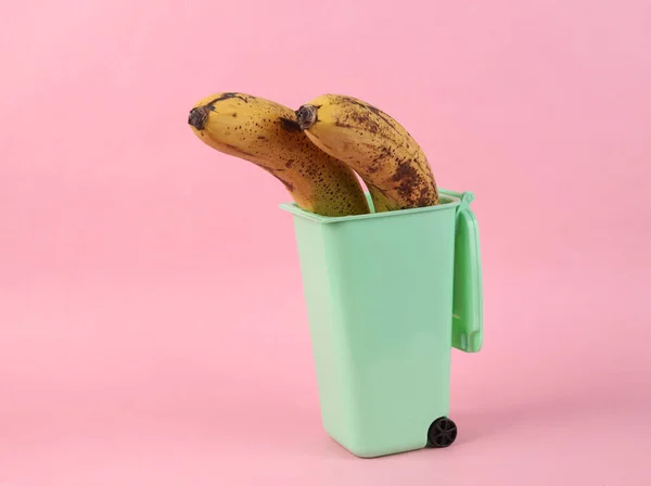 Bananes Gâtées Dans Une Mini Poubelle Sur Fond Rose — Photo