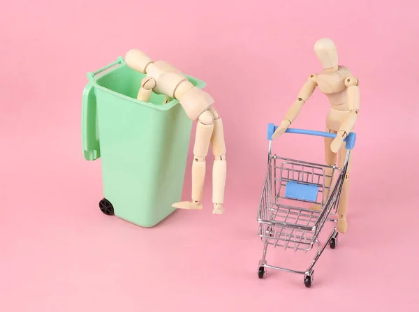 ゴミをゴミ箱に詰め ピンクの背景にショッピングカートで運転する人形劇のシーン — ストック写真