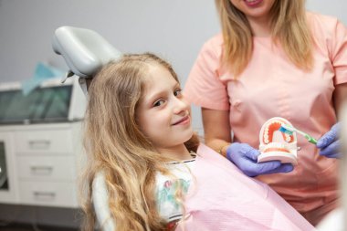Little Caucasian smiling girl on examination at the dentist in dental clinic