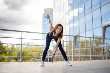 Genç fitness kadını şehir binası yakınlarında ısınma egzersizleri yapıyor. sağlıklı yaşam tarzı