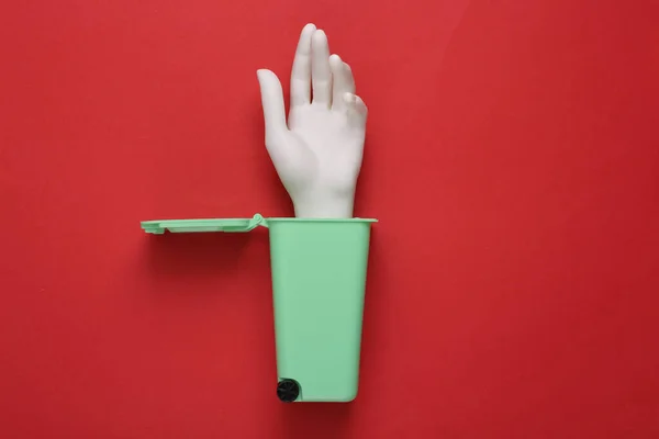 Model Tangan Plastik Dalam Tong Sampah Pada Latar Belakang Merah — Stok Foto