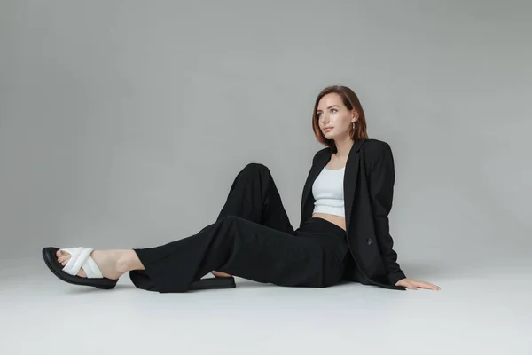 Мода Стильную Модницу Черном Костюме Сидящую Полу Студии — стоковое фото