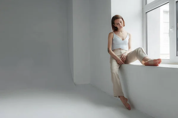 Mulher Elegante Jovem Sentado Por Uma Janela Luz Quarto Branco — Fotografia de Stock