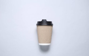 Gri bir arka planda karton bardakla poz ver. Üst görünüm