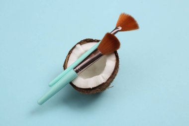 Mavi arka planda hindistan cevizli makyaj fırçaları
