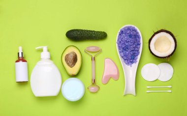 Yeşil arka planda meyve ve sebzeli kozmetik ürünlerin oluşturduğu yaratıcı düz bir set. Üst görünüm