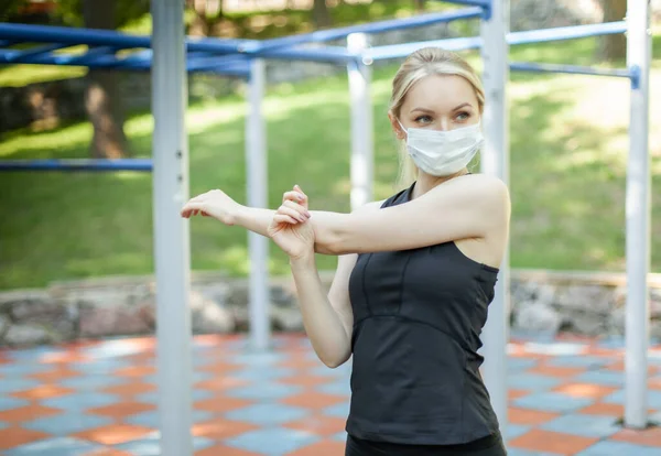 Giovane Donna Forma Facendo Stretching Mano Maschera Medica Sul Sito — Foto Stock