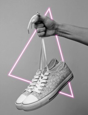 Spor ayakkabılarını bağcıklarından tut. 80 'lerin sentetik dalgası ve parlayan üçgen fütüristik estetiği. Eski moda soyutlama kavramı