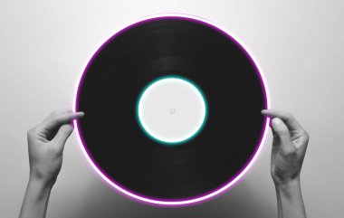 Retro vinil plağı tutan kadın eller. 80 'lerin sentetik dalgası ve parlayan retrodalga daire fütüristik estetiği. Eski moda soyutlama kavramı