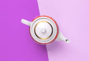 Mor kağıttan arka planda Retro seramik çaydanlık. Üst görünüm