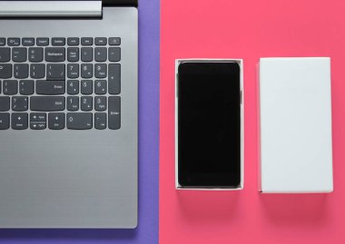 Boksu açma, tekno blog yazma kavramı. Yeni akıllı telefon kutusu, pembe mor arka planda dizüstü bilgisayar. Üst görünüm