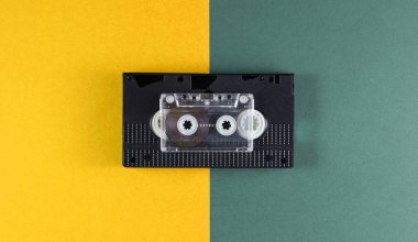 Yeşil-sarı arka planda ses ve video kaseti. Retro tarzı. Üst görünüm.