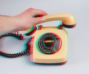 Gri arka planda dönen eski bir telefon ahizesi tutan bir erkek el. Arıza efekti
