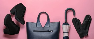 Pembe arka planda kadın sonbahar ayakkabıları ve aksesuarları. Deri eldivenler, botlar, şemsiye. Üst görünüm