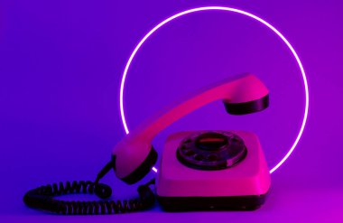 Yükselen telefon saplı eski tarz bir telefon. 80 'lerin sentetik dalgası ve parlayan retrodalga daire fütüristik estetiği. Eski moda soyutlama kavramı