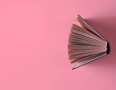Pembe arka planla ilgili eski kitabı aç. Üst görünüm, minimalizm