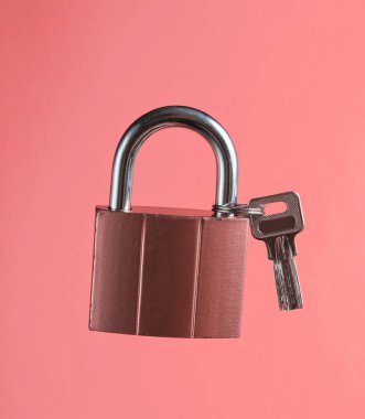 Metal lock with key on vanilla pink background