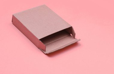 Empty cardboard box on vanilla pink paper background