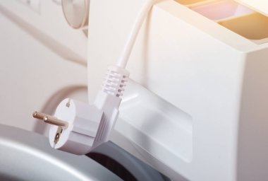 Elektrik prizi ile yakın plan çamaşır makinesi parçası.