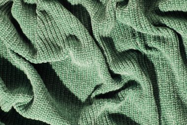 Texture of crumpled green knitted. Top view