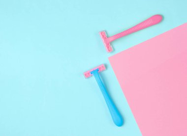 Minimalist güzellik konsepti. Epilasyon. Pastel arka planda plastik renkli jiletler. Üst görünüm