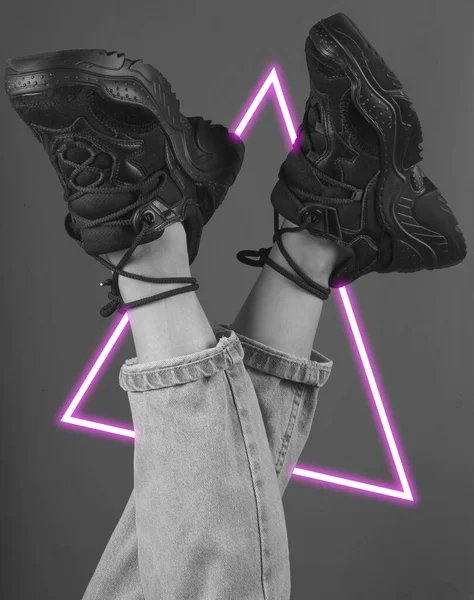 Kot pantolon ve spor ayakkabı giymiş bir kadının bacakları. 80 'lerin sentetik dalgası ve parlayan üçgen fütüristik estetiği. Eski moda soyutlama kavramı